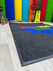 Ev veya iş yeri girişinde kullanılan kişiye özel logolu paspas, güvenli ve şık kullanım