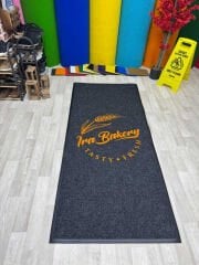 Restoran girişinde yerleştirilmiş logolu kapı önü paspas, estetik ve güvenli kullanım