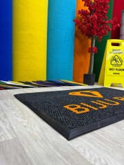 Kapı önü paspasın logolu baskı detayı ve kaliteli malzeme görünümü